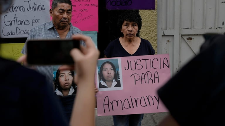 Mario Roblero and Cecilia Gonzalez hold images of their missing...