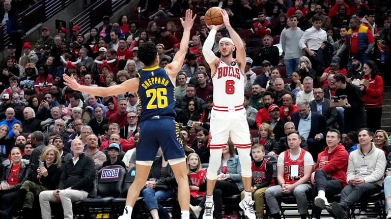 Chicago Bulls guard Alex Caruso, right, shoots against Indiana Pacers...