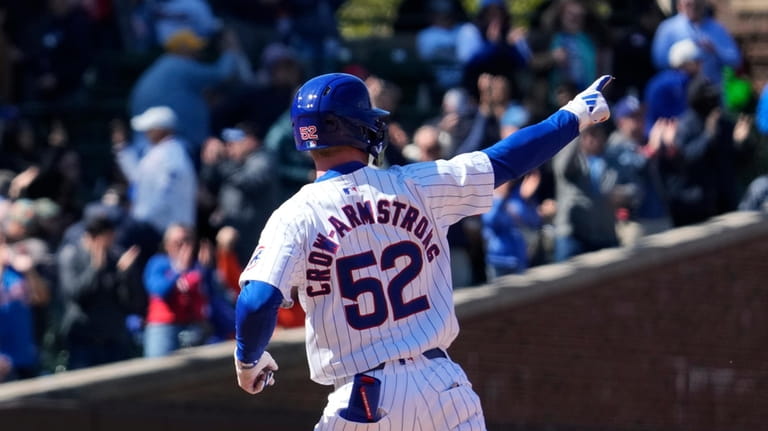Chicago Cubs' Pete Crow-Armstrong points as he rounds the bases...