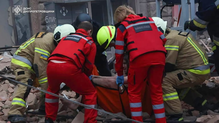 In this photo provided by the Ukrainian Emergency Service, rescuers...
