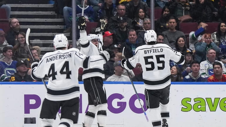 Los Angeles Kings' Anze Kopitar, center, Quinton Byfield (55) and...