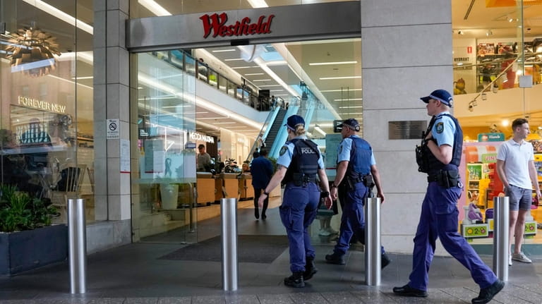 Police officers walk into the Westfield shopping mall at Bondi...