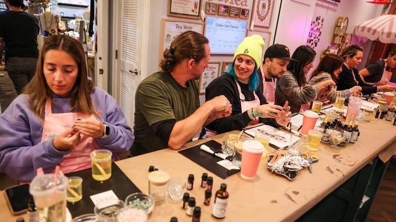Participants mix up soy candles with essential oils during the...