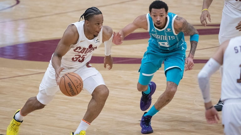 Cleveland Cavaliers' Isaac Okoro (35) is guarded by Charlotte Hornets'...