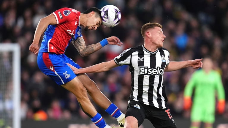 Crystal Palace's Daniel Munoz, left, heads the ball over Newcastle...