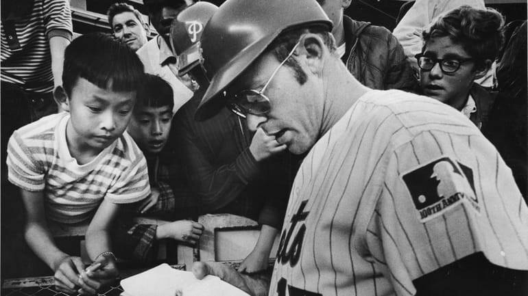 Mets catcher Jerry Grote signs an autograph book at Shea Stadium...