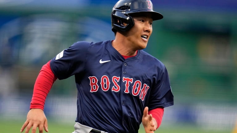 Boston Red Sox's Masataka Yoshida attempts to score from first...