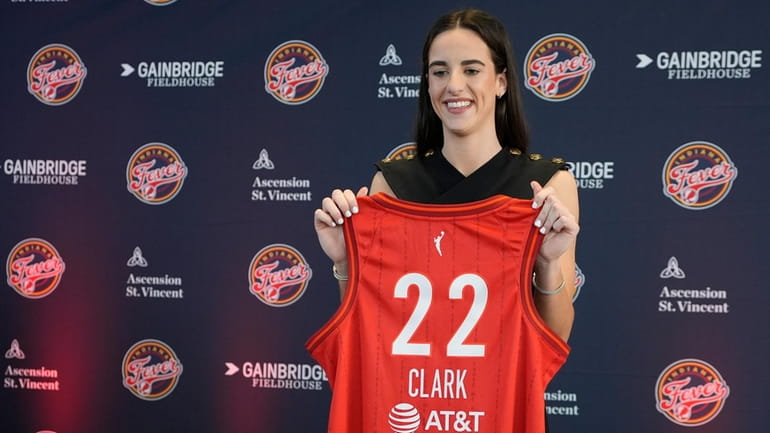Indiana Fever's Caitlin Clark holds her jersey following a WNBA...