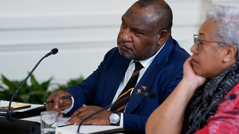 Papua New Guinean Prime Minister James Marape, left, listens during...