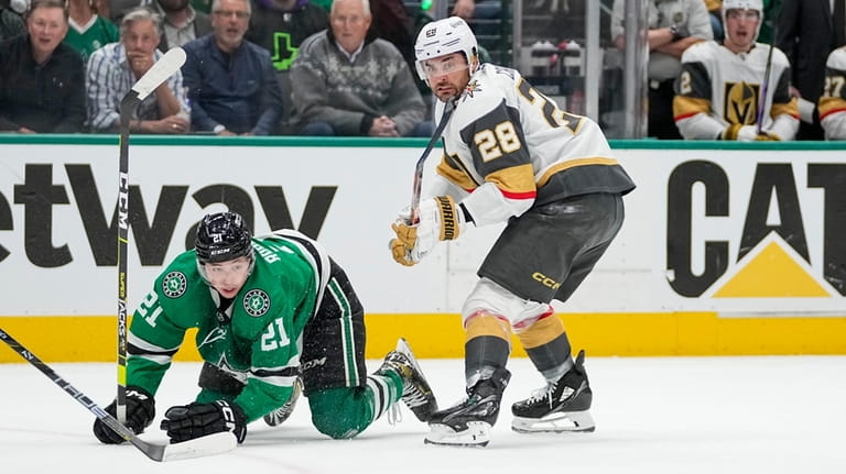 Dallas Stars left wing Jason Robertson (21) is tripped up...