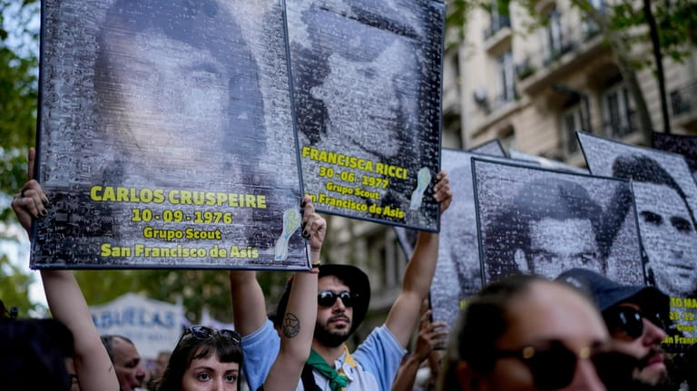 Demonstrators display photos of people who disappeared during the 1976-1983...