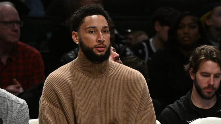 Nets guard Ben Simmons looks on from the bench in...