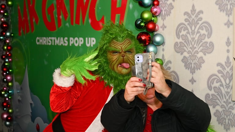 Charles Jacker as Mr. Grinch takes a selfie with a...