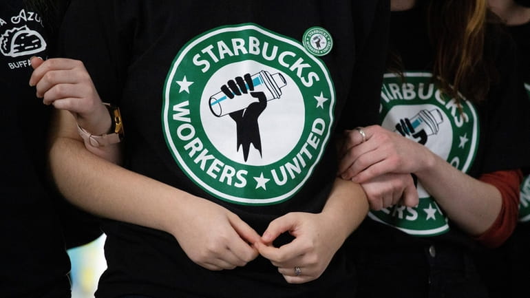 Starbucks employees and supporters link arms during a union election...