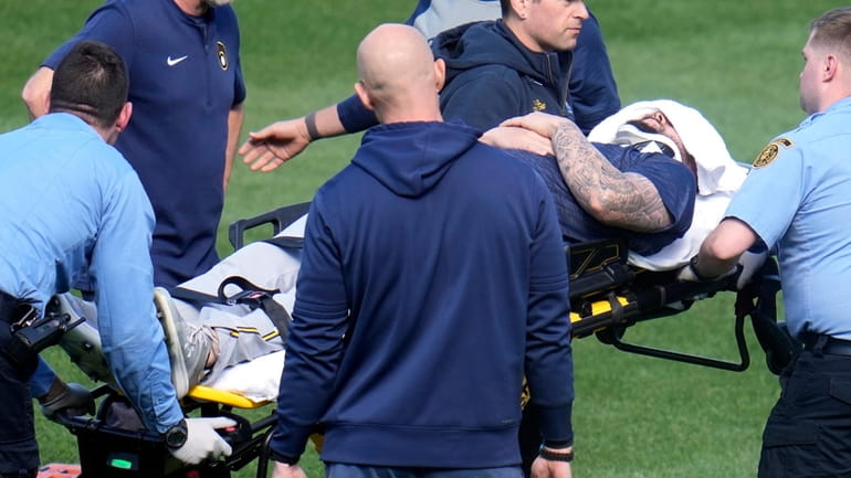 Milwaukee Brewers pitcher Jakob Junis is wheeled to an ambulance...