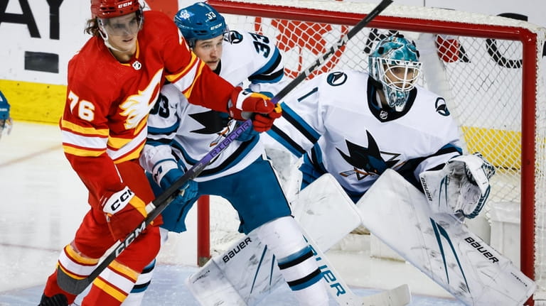 San Jose Sharks defenseman Calen Addison (33) checks Calgary Flames...