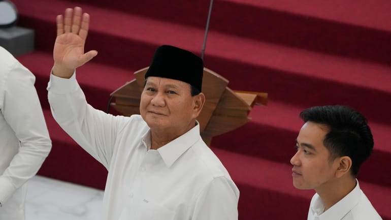 Indonesian Defense Minister and president-elect Prabowo Subianto, left, waves at...