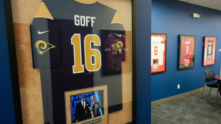 A framed Los Angeles Rams Jared Goff jersey hangs on...