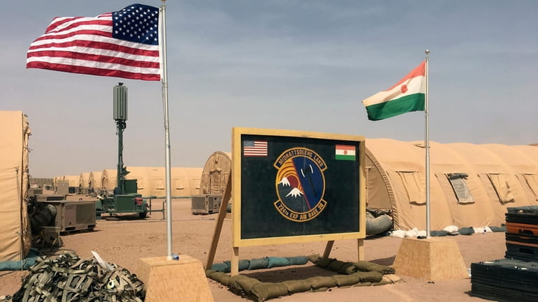 A U.S. and Niger flag are raised side by side...