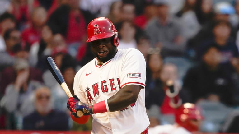 Los Angeles Angels' Miguel Sano reacts to a wild pitch...