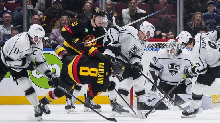 Los Angeles Kings goalie Cam Talbot, back right, stops a...