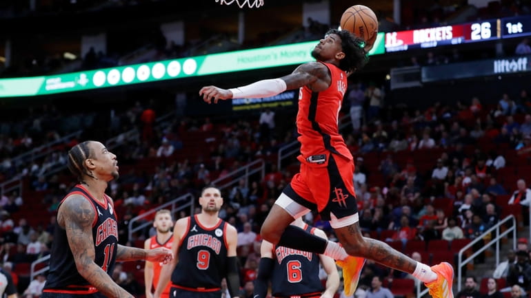 Houston Rockets guard Jalen Green, top, dunks over Chicago Bulls...