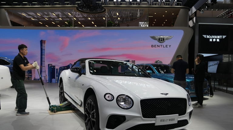 A worker prepares at a Bentley booth for the upcoming...