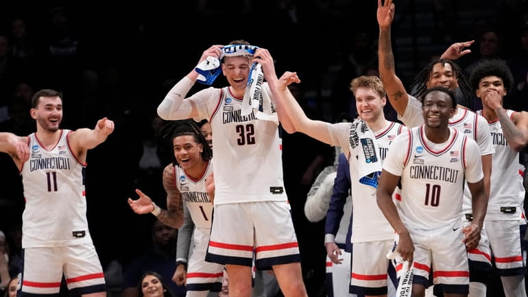 UConn center Donovan Clingan (32) and his teammates reacts in...