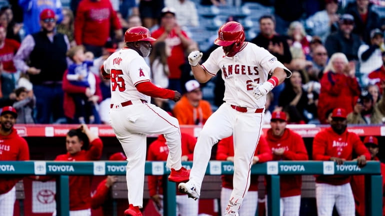 Los Angeles Angels' Mike Trout, right, celebrates his home run...