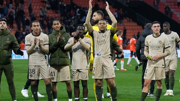 PSG players with Kylian Mbappe, arms in the air, celebrate...