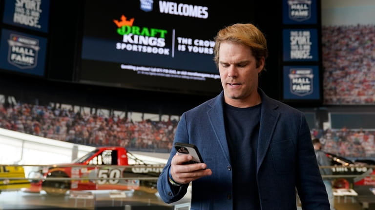 Fox Sports broadcaster Greg Olsen retrieves his receipt after placing...