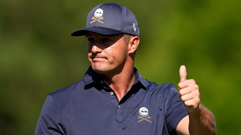 Bryson DeChambeau gestures after finishing the 12th hole during final...