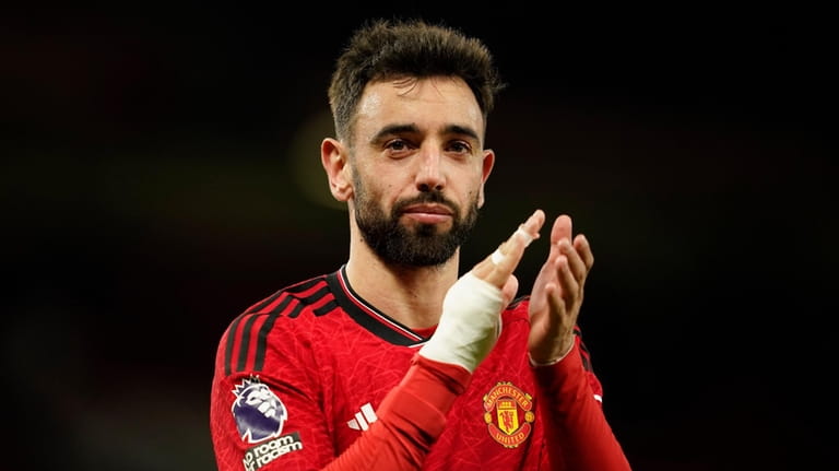 Manchester United's Bruno Fernandes waves his fans at the end...