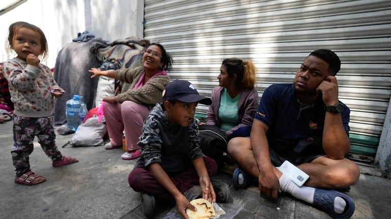 A migrant family from Venezuela eats breakfast alongside the railroad...