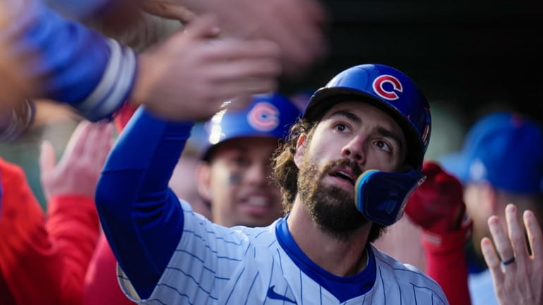 Chicago Cubs' Dansby Swanson is congratulated in the dugout after...
