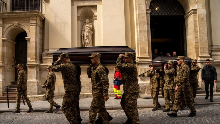 Soldiers carry the coffins of two Ukrainian army sergeants during...