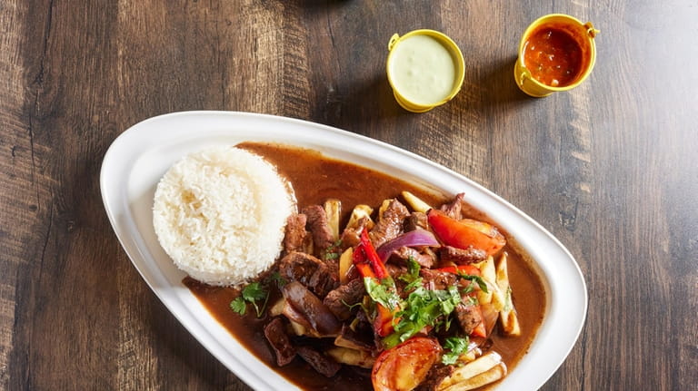 Lomo saltado with beef sirloin, red peppers, onions, tomato and...
