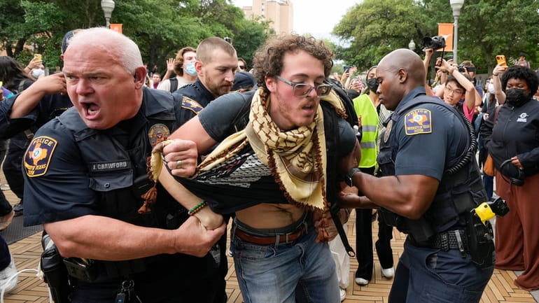 University of Texas police officers arrest a man at a...