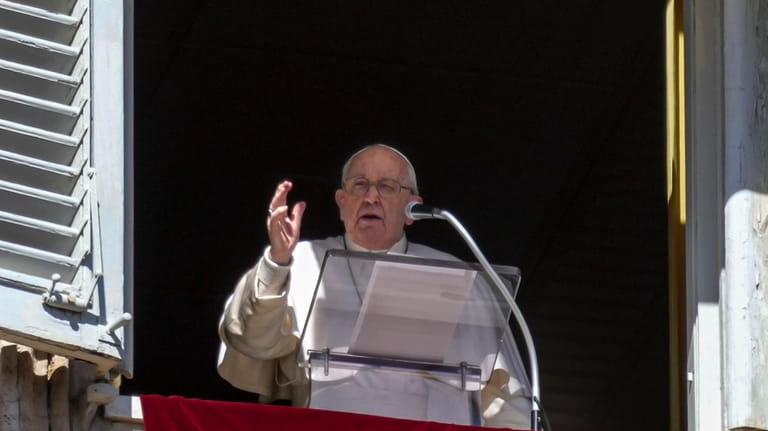 Pope Francis appears at the window of his studio overlooking...