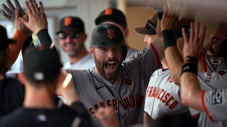 San Francisco Giants' Curt Casali, center, celebrates with teammates in...