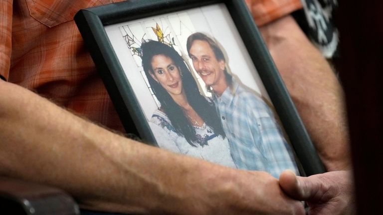 Family members of Dennis Tuttle and Rhogena Nicholas bring a...