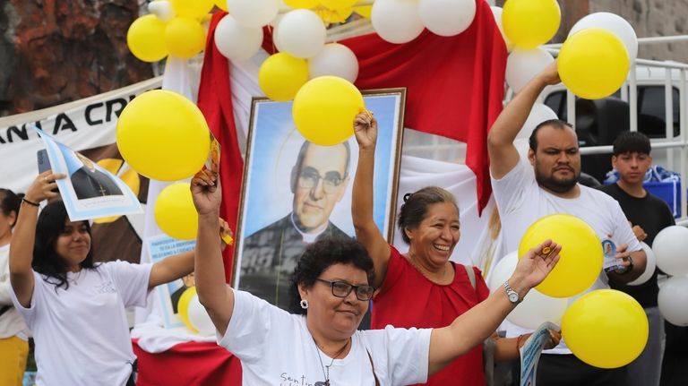 People carry balloons and an image of Saint Oscar Arnulfo...