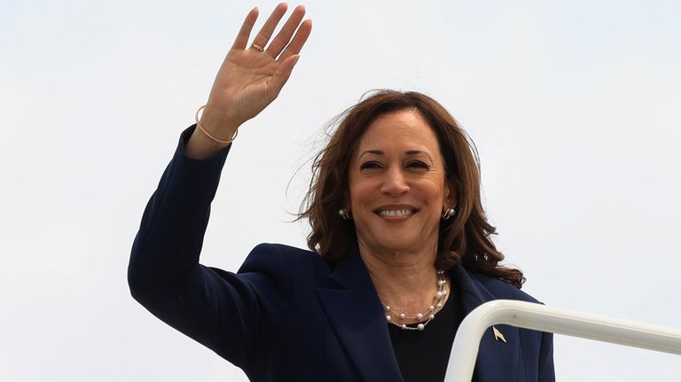 Vice President Kamala Harris waves as she boards Air Force...