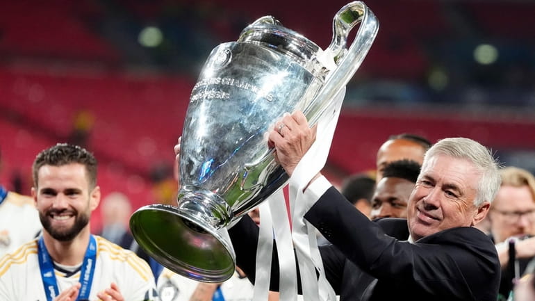Real Madrid manager Carlo Ancelotti celebrates with the trophy after...