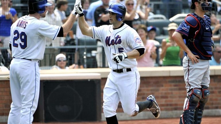 Mets' David Wright, center, runs past Twins' catcher Joe Mauer,...