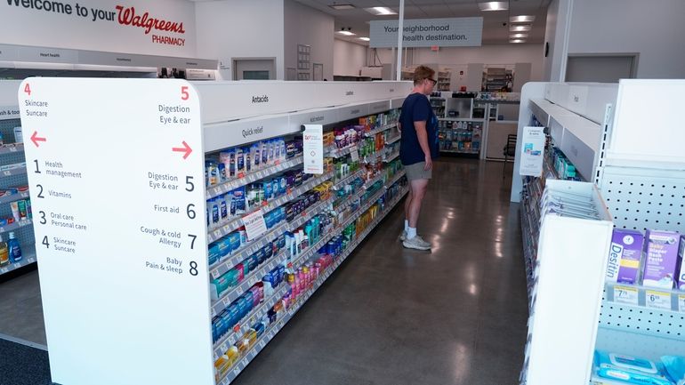 A customer browses an aisle at a Walgreens pharmacy store...