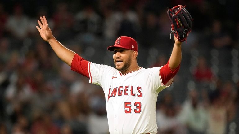 Los Angeles Angels relief pitcher Carlos Estevez gestures after Texas...