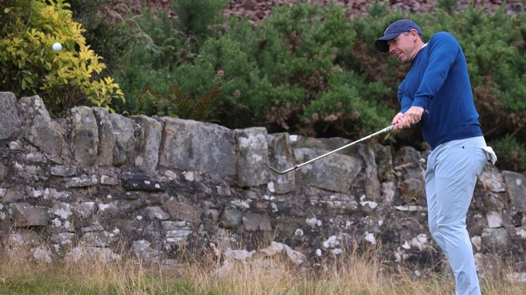 Rory McIlroy of Northern Ireland watches his chip shot during...