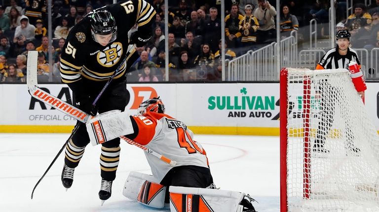 Boston Bruins' Matthew Poitras (51) misses his shot against Philadelphia...