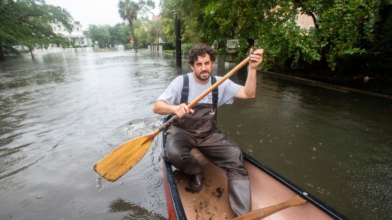 Trip Hamilton, from Charleston, S.C., canoes down Ashley Ave in...